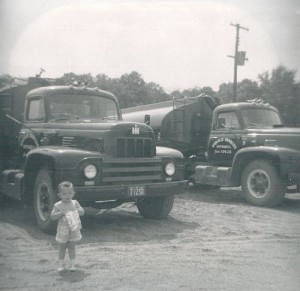 Denis Marcus pictured in front of new tractor trailers. (August 1955)